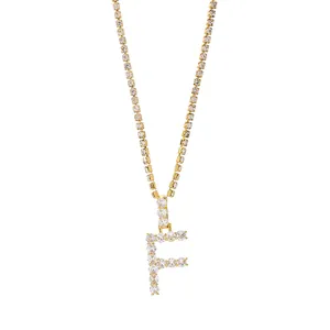 Gedetailleerde opname van een gouden tennisketting met een ijskoude letter F-hanger