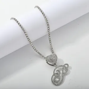 Detailed close-up of a silver-toned tennis chain with iced out cursive letter P pendant