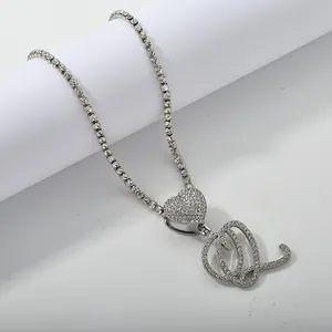 Macro shot of silver letter Q pendant with heart link and iced out tennis chain