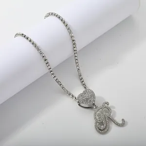 Macro detail of iced out tennis chain with heart pendant and sparkling cursive letter R