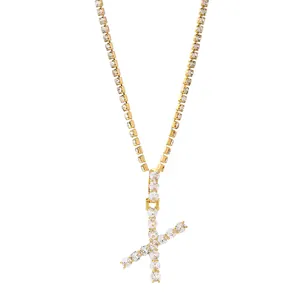Detail van de gouden tennisketting met glanzende letter X hanger met kristallen