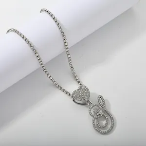 Macro shot of silver tennis necklace with iced out heart and script letter S pendant