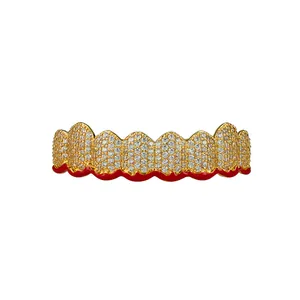 Macro detail of hip-hop grillz with pavé zircons and red enamel wave on gold-plated copper