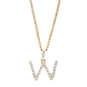 Detailopname van de gouden letter W hanger met fonkelende kristallen op een tennisketting