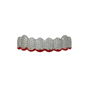 Macro shot of silver hip hop grillz with white zircons and unique red drip edge detail