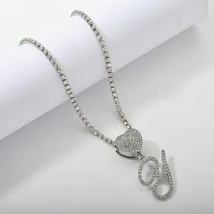Macro detail of silver tennis chain with iced out heart and cursive letter Y pendant