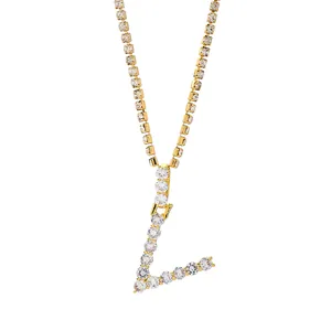 Detailopname van vergulde letter L hanger bezet met kristallen en glanzende tennis ketting