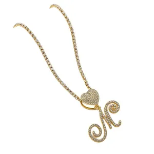Gold plated tennis chain with iced out heart and cursive letter M pendant for women