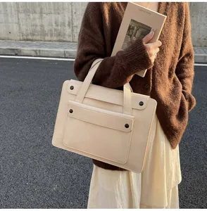 Detail of cream laptop briefcase with front flap pocket and dual handles for women