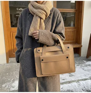 Outdoor street view of a khaki laptop briefcase with front flap and round buckle
