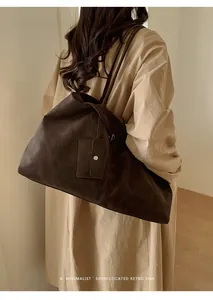 Detail view of large dark brown suede tote bag showing texture and matching pouch