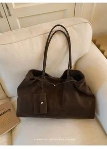 Detail of deep brown tote bag with suede texture and matching mini coin purse accessory