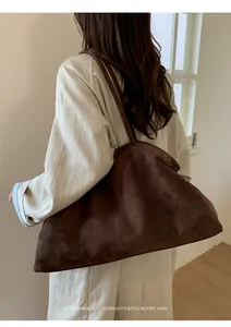 Deep brown faux suede tote bag on shoulder, showcasing minimalist retro vibe and large size