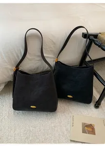 Detail view of retro matte bucket bags in black and dark coffee with gold buckles