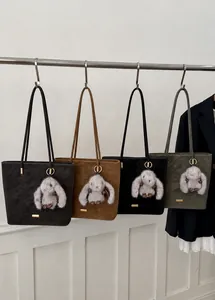 Detailansicht großer Beuteltaschen in vier Farben mit Plüsch-Kaninchen-Anhängern