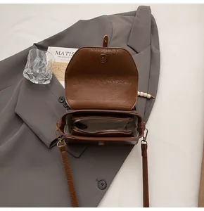 Detailed interior of vintage brown crossbody bag with functional compartments and lining