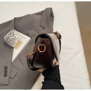 Detailed close-up of dark brown leather saddle bag with vintage bronze metal buckle