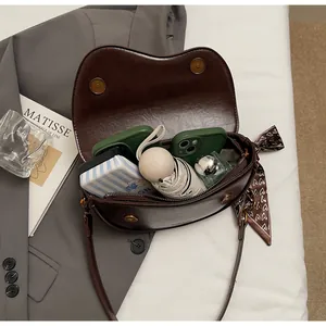 Top view of spacious interior of brown saddle bag showing umbrella and phone storage