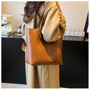 Modella che indossa una borsa tote marrone retrò capiente con tracolla regolabile