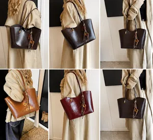 Vista dettagliata di grandi borse tote vintage in marrone scuro e bordeaux con nappe
