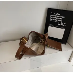 Close-up of large brown PU leather tote bag showing spacious interior and golden hardware