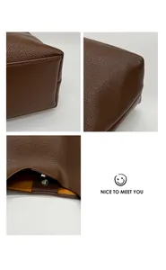 Detailed macro view of brown lychee grain leather handbag with silver magnetic closure