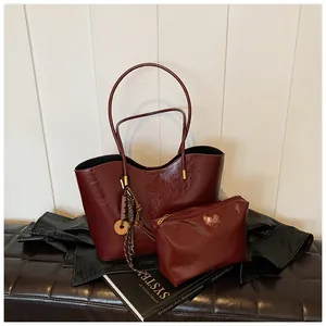 Dettaglio della borsa tote rosso vino in ecopelle con pochette abbinata su panca