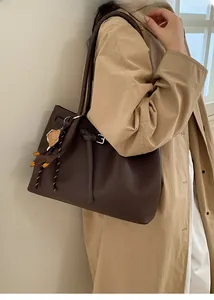 Bolso tote de cuero granulado marrón oscuro con hebilla plateada y colgante de oso