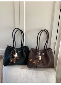 Detalle de bolsos tote vintage en negro y marrón oscuro con lindos colgantes de perro y béisbol
