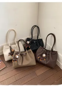 Vista de detalle de cuatro bolsos tote en colores contrastados con colgantes de perro