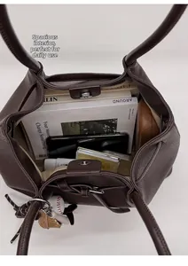 Vista macro del interior de un gran bolso tote de cuero marrón con cierre magnético y espacio