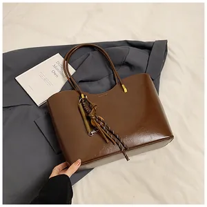 Dettaglio della borsa tote vintage in pelle marrone con bordo a onde e decoro in corda