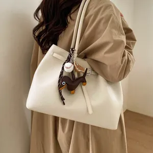 Bolso tote crema elegante en cuero con textura de grano y colgante de perro salchicha