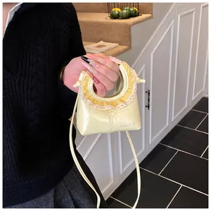 Detail of cream tote bag featuring lace ruffle handle and Helane logo branding