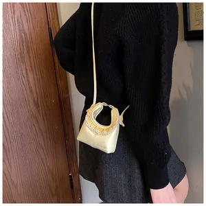 Close-up of yellow bag with delicate white lace trim and pleated ruffle details