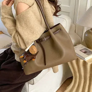 Detalle del bolso tote kaki con textura litchi y colgante de perro salchicha de cuero