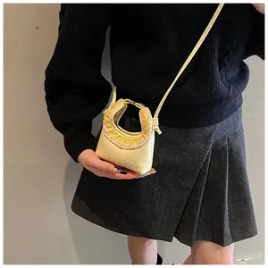 Detail showing yellow mini crossbody bag with delicate lace trim and ruffle edges