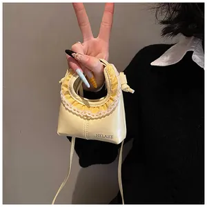 Detail of cream yellow leather bag featuring lace trim and yellow plaid fabric edge