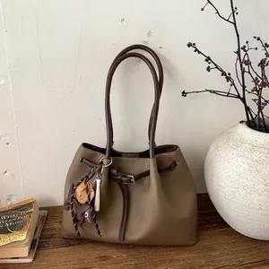 Detalle macro del bolso tote de cuero granulado marrón con correas decorativas