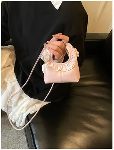 Close-up of a pink PU leather bag with white lace trim and branded logo detail