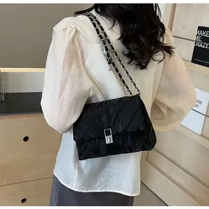 Details einer schwarzen Stepptasche mit silbernem Drehverschluss und Kettenriemen