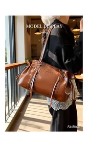 Brown faux leather Boston bag with side drawstring detail and stylish tassel accessory
