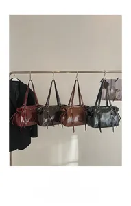 Row of minimalist glossy leather Boston bags in burgundy, brown, tan, and black colors