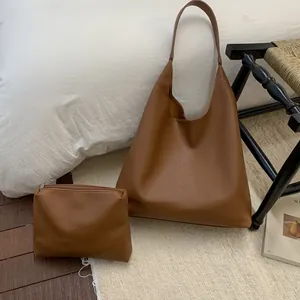 Detailed view of brown lychee-patterned tote bag and small matching makeup pouch