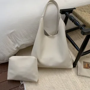 Detail of off-white lychee grain tote bag set with matching zipper pouch in home setting