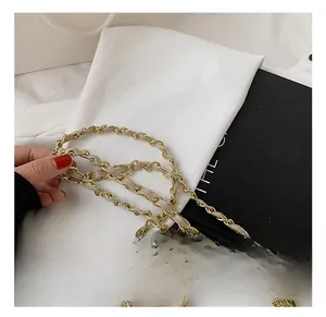 Detail of light gold chain strap with woven beige leather for elegant shoulder bags
