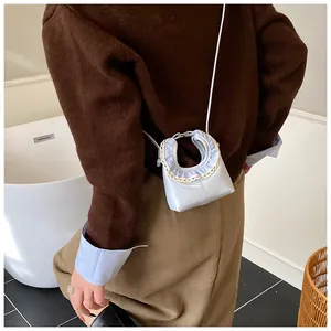 Detail of light blue crossbody bag featuring ruffled lace trim and HERAHE branding