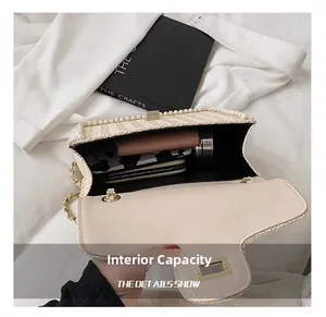 Internal capacity detail of straw shoulder bag with pearls showing phone and wallet