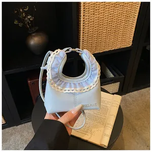 Close-up of light blue handbag featuring white lace trim and plaid ruffle detail