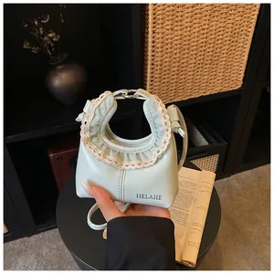 Detailed shot of mint green tote bag featuring delicate white lace trim and logo detail